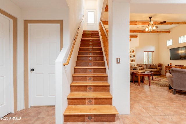 staircase featuring a ceiling fan, beamed ceiling, and tile patterned floors