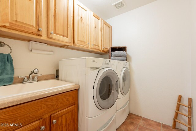 laundry area featuring a sink, washing machine and dryer, cabinet space, and visible vents