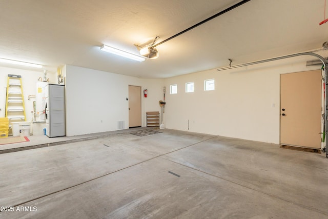 garage featuring fridge and a garage door opener