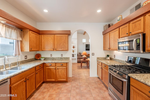 kitchen with visible vents, recessed lighting, arched walkways, a sink, and appliances with stainless steel finishes