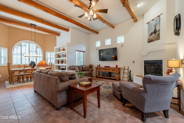 living room featuring beamed ceiling, a ceiling fan, a high ceiling, and tile patterned flooring