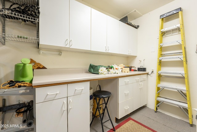 interior space with light countertops, white cabinets, and light colored carpet