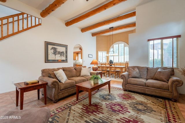 living room with arched walkways and beamed ceiling