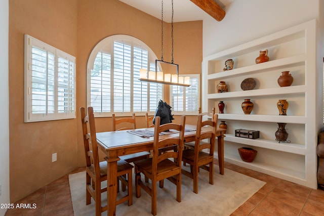 tiled dining room with beamed ceiling and built in shelves