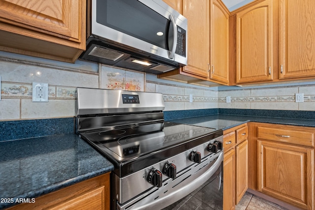 kitchen with light tile patterned floors, stainless steel appliances, and backsplash