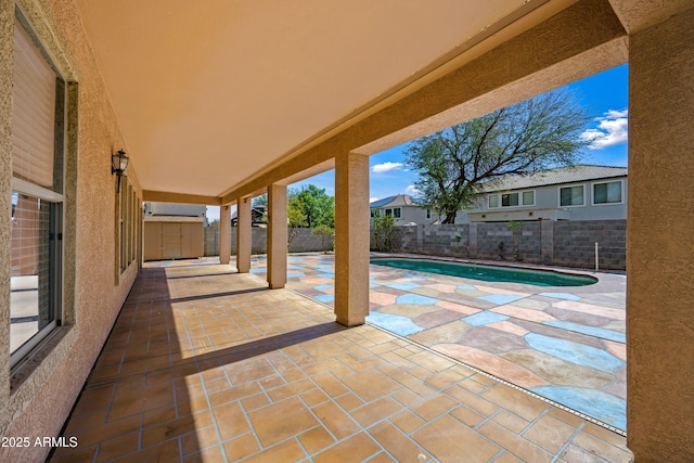 view of patio / terrace with a storage shed, a fenced backyard, a fenced in pool, and an outbuilding