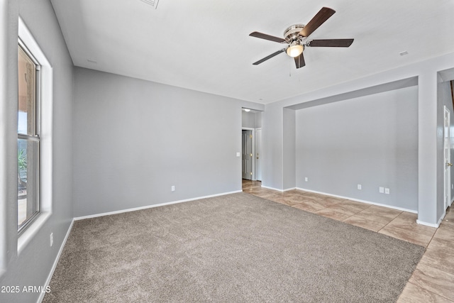 carpeted empty room with ceiling fan and baseboards