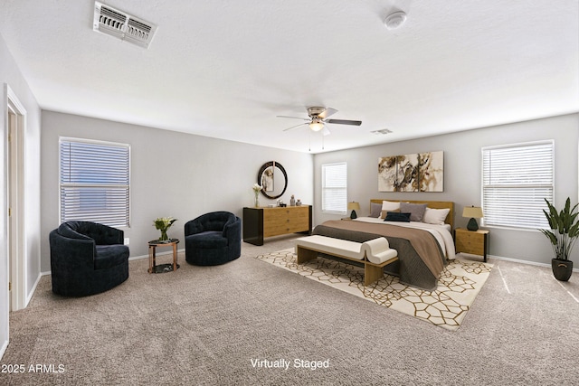 carpeted bedroom featuring a ceiling fan, visible vents, and baseboards