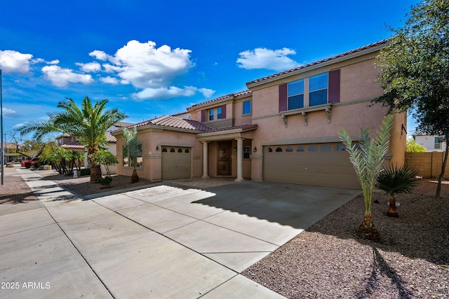 mediterranean / spanish house with driveway, a tiled roof, an attached garage, and stucco siding