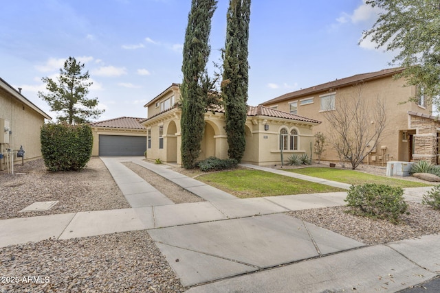 mediterranean / spanish-style home featuring stucco siding, an outbuilding, driveway, a tile roof, and an attached garage