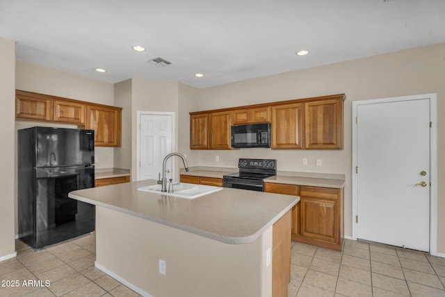 kitchen with black appliances, brown cabinetry, visible vents, and a sink