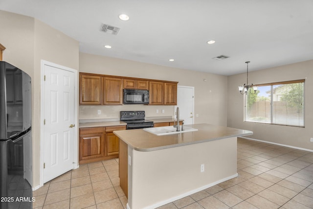 kitchen with black appliances, brown cabinetry, light countertops, and visible vents