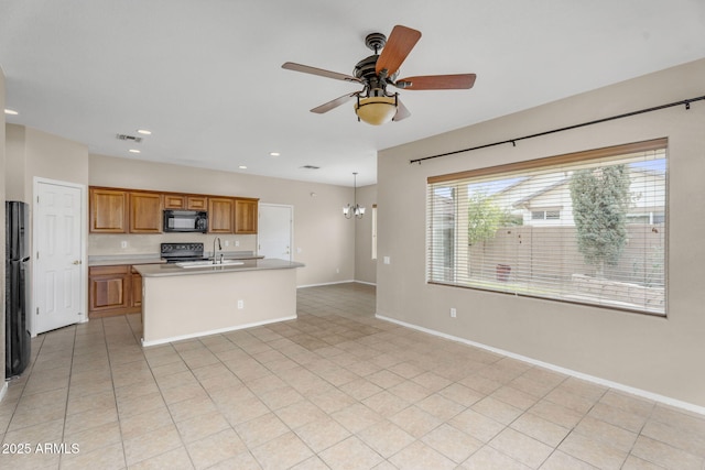 kitchen featuring black appliances, a sink, brown cabinetry, light countertops, and baseboards