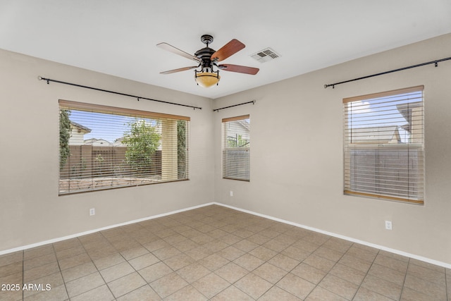 spare room with a ceiling fan, baseboards, and visible vents