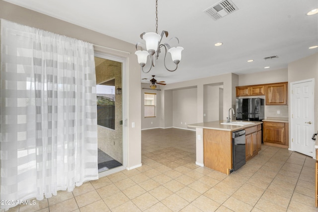 kitchen featuring brown cabinetry, visible vents, black appliances, and light countertops