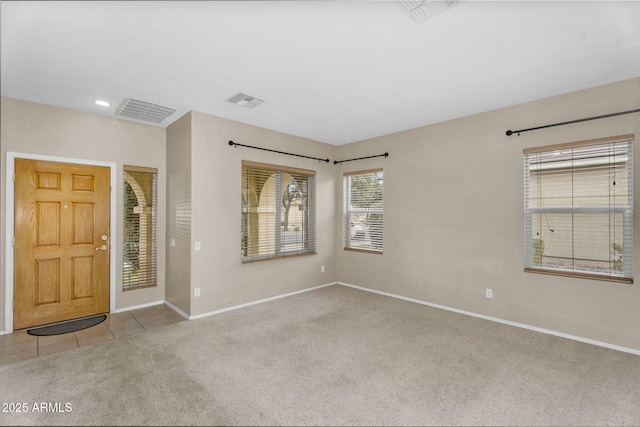 carpeted entryway featuring tile patterned floors, visible vents, and baseboards