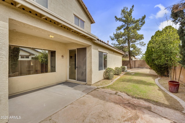 exterior space featuring stucco siding, fence, and a patio area