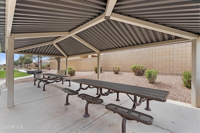 view of community featuring outdoor dining area, a patio, and fence