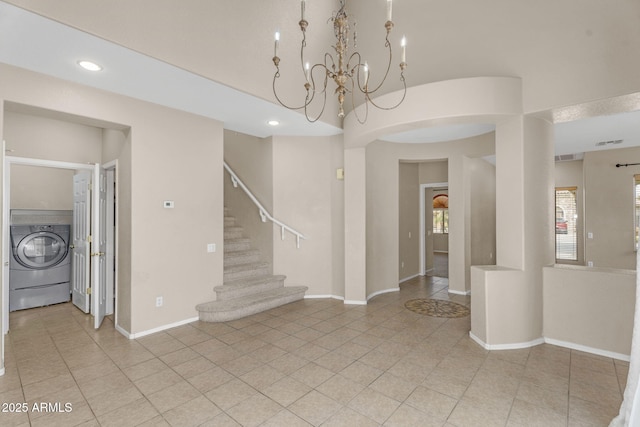 interior space featuring stairway, light tile patterned floors, baseboards, washer / dryer, and a chandelier