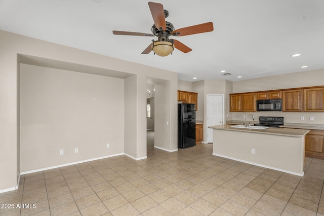 kitchen featuring a sink, black appliances, brown cabinetry, and light countertops