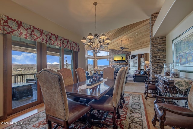 dining room with wood-type flooring, high vaulted ceiling, and a notable chandelier