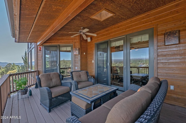 wooden terrace with outdoor lounge area and ceiling fan