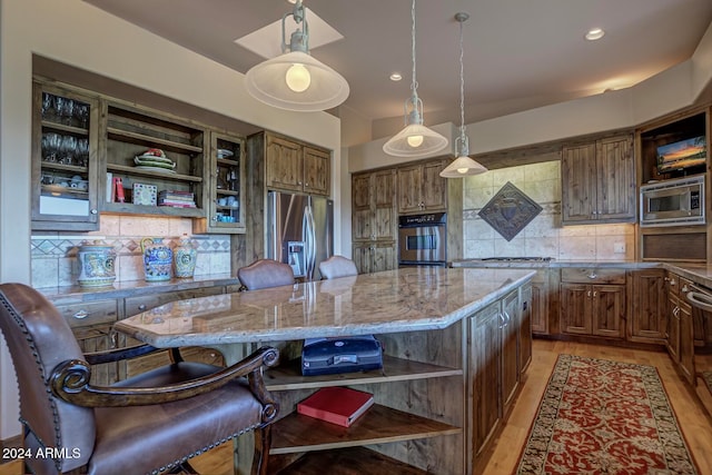 kitchen with tasteful backsplash, light hardwood / wood-style flooring, a kitchen island, and stainless steel appliances