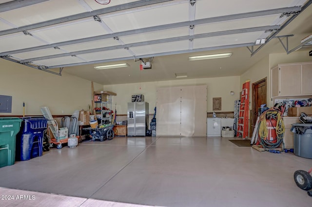 garage with stainless steel fridge, electric panel, and a garage door opener