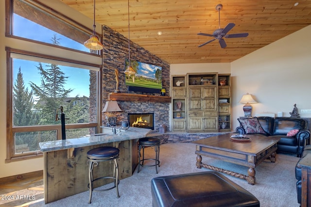 living room with wooden ceiling, high vaulted ceiling, a stone fireplace, ceiling fan, and light colored carpet