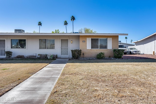 ranch-style house with central AC unit and a front lawn