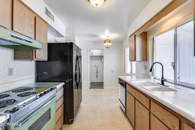 kitchen featuring a chandelier, pendant lighting, stainless steel appliances, decorative backsplash, and sink