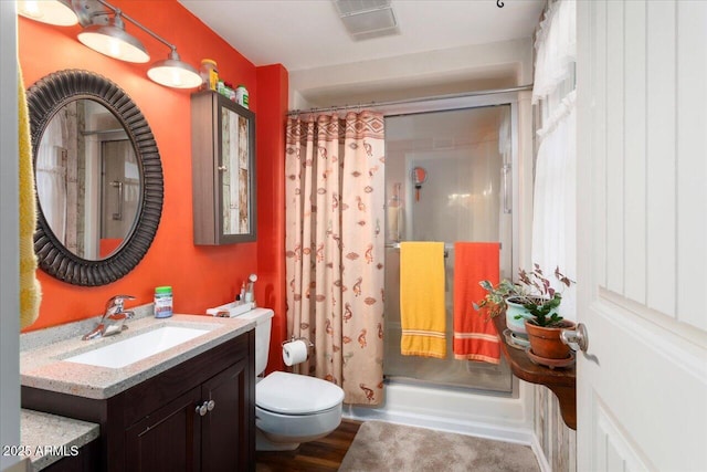 bathroom featuring toilet, walk in shower, hardwood / wood-style floors, and vanity