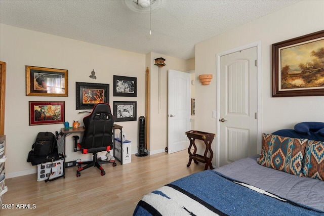 bedroom with a textured ceiling and light hardwood / wood-style flooring