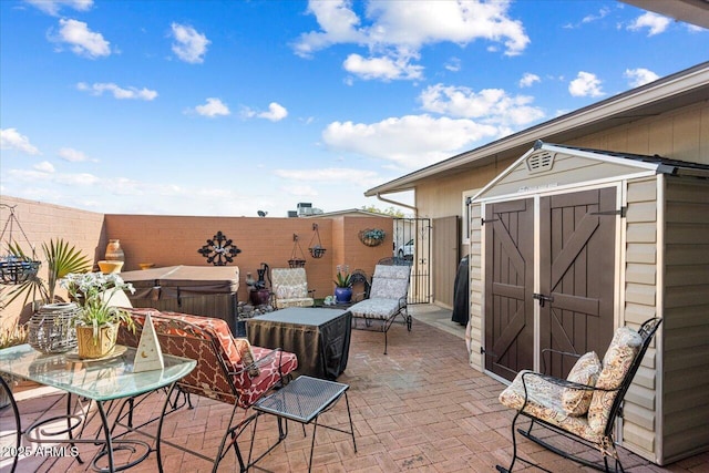 view of patio / terrace featuring a shed and a hot tub