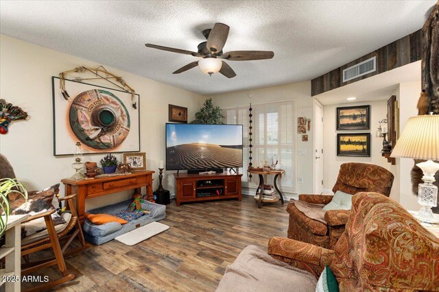 living room with wood-type flooring, a textured ceiling, and ceiling fan