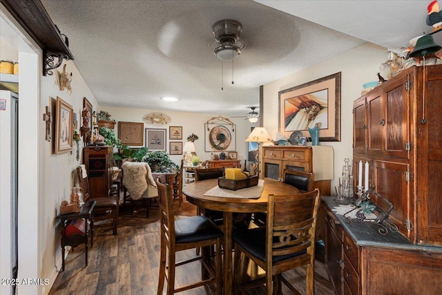 dining space featuring ceiling fan, dark hardwood / wood-style floors, and a textured ceiling