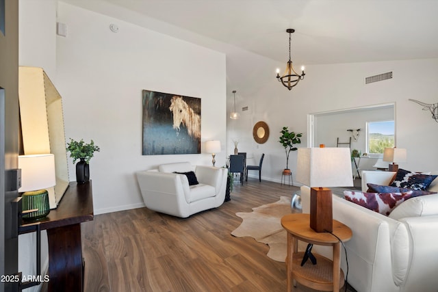 living room featuring an inviting chandelier, hardwood / wood-style flooring, and high vaulted ceiling