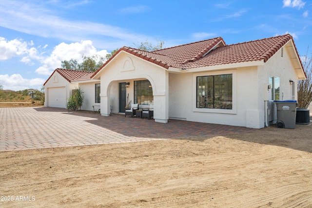 view of front facade featuring a garage and cooling unit