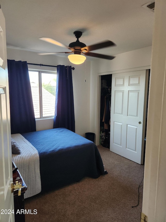 carpeted bedroom with ceiling fan and a closet