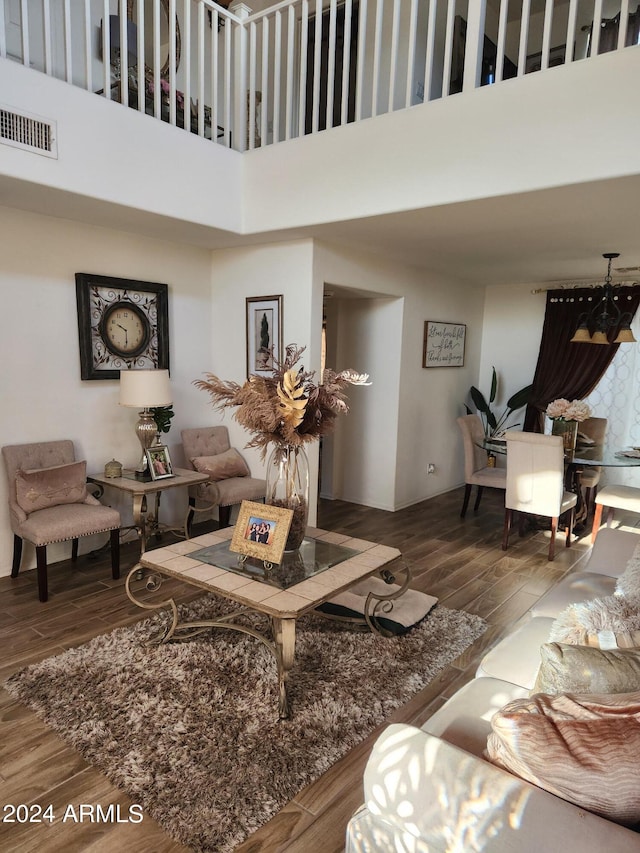 living room with wood-type flooring and a towering ceiling