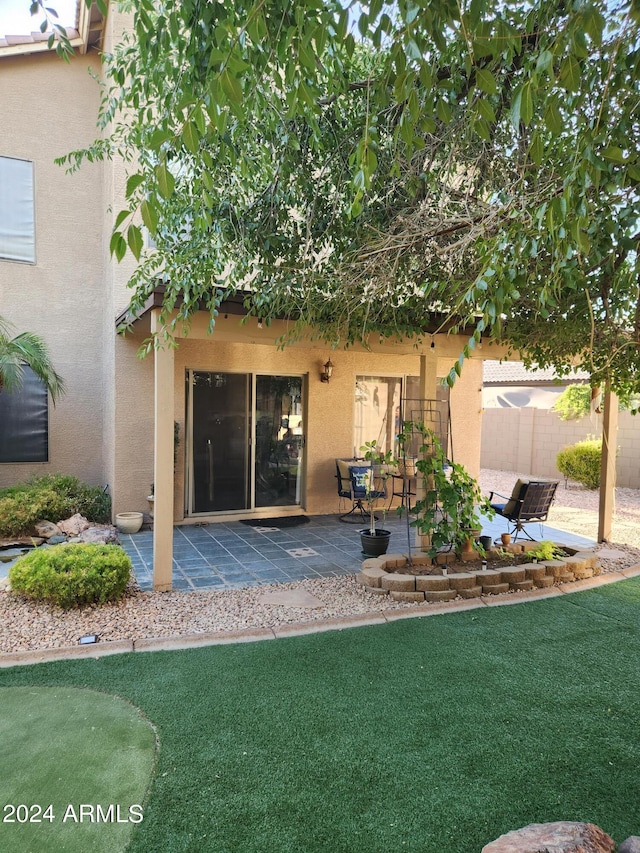 back of property featuring a lawn and a patio