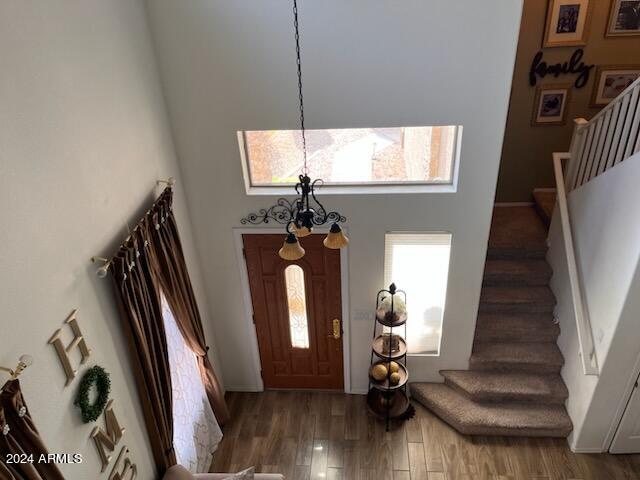 foyer with a high ceiling, a chandelier, and hardwood / wood-style floors