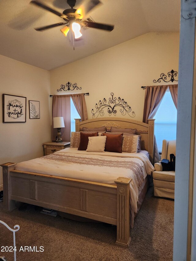 bedroom featuring carpet flooring, vaulted ceiling, ceiling fan, and multiple windows