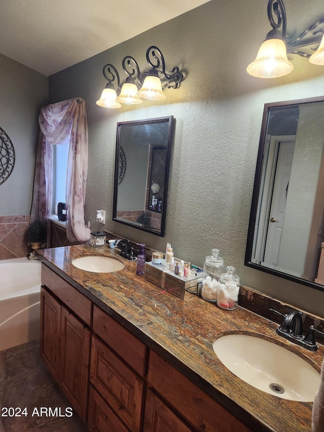 bathroom featuring double sink vanity, a tub, a textured ceiling, and tile patterned flooring