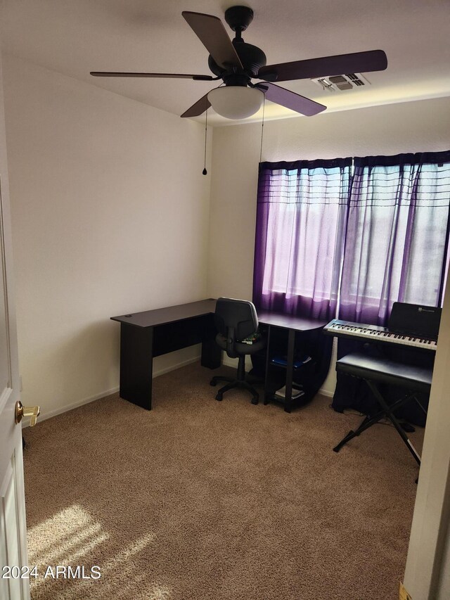 carpeted office space featuring ceiling fan