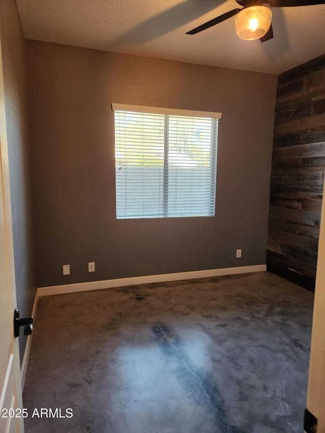 spare room with wooden walls and ceiling fan