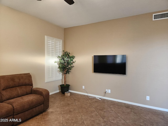 living area featuring tile patterned floors and ceiling fan