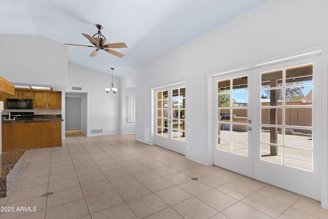 interior space with light tile patterned floors, french doors, dark countertops, and black microwave