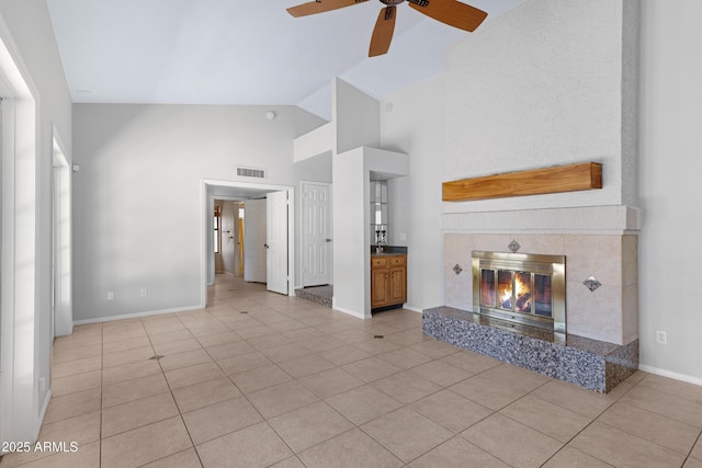 unfurnished living room featuring visible vents, baseboards, light tile patterned floors, a fireplace, and a ceiling fan