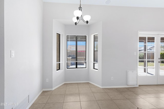 unfurnished room with light tile patterned floors, visible vents, baseboards, and a chandelier